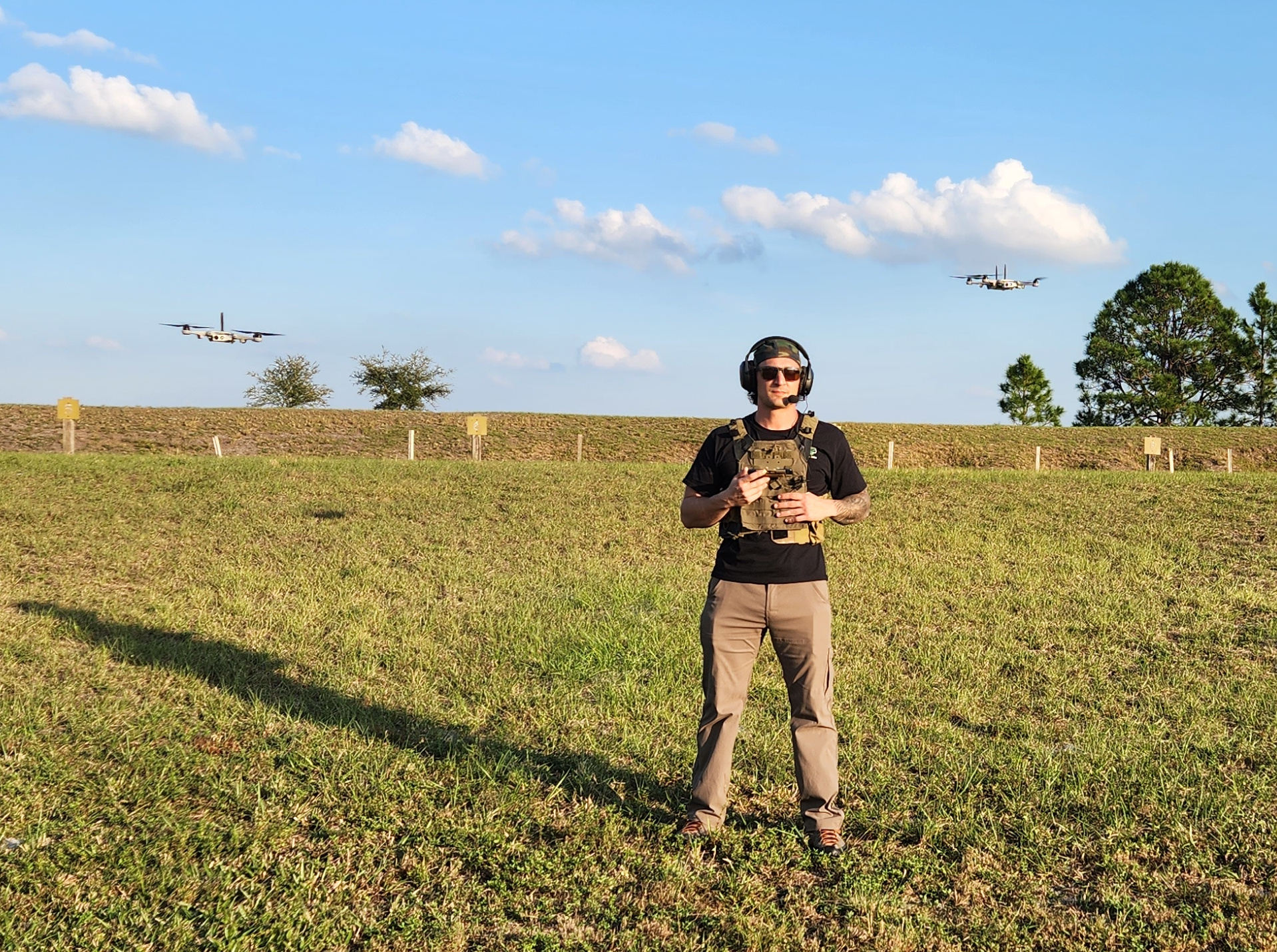a person wiith 2 drones flying behind them